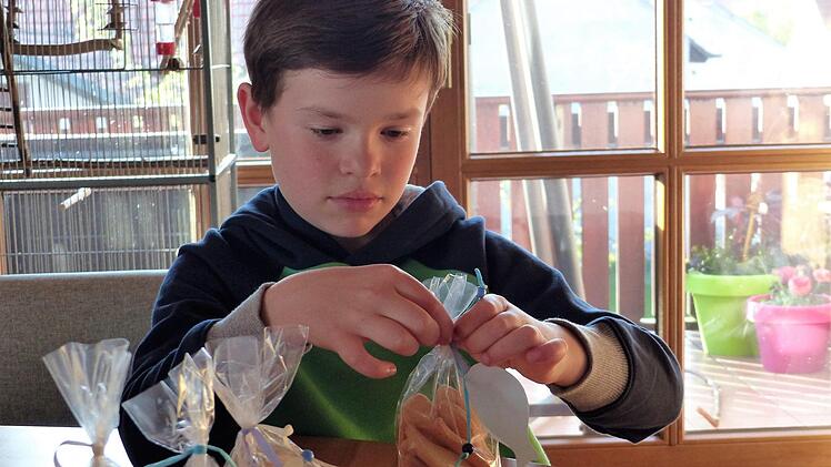 BU Geschenk: Mit voller Konzentration verpackt Felix die selbst gebackenen Plätzchen, die als Aufmerksamkeit für Gratulanten gibt. Fotos. Christian Ziegler