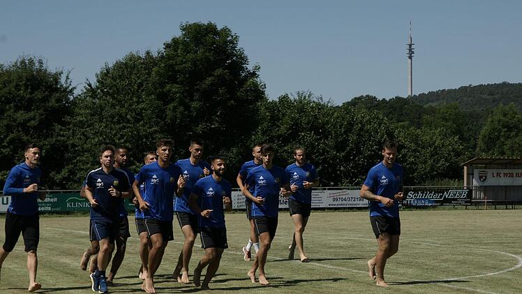 Einige Profis des 1. FC Saarbr&uuml;cken auf dem Fu&szlig;ballplatz des FC Elfershausen. Hinten der markante Fernsehturm bei Feuerthal. Foto: Steffen Standke