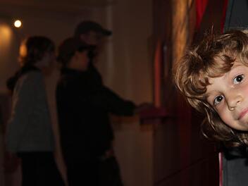 Als einer der letzten Gäste stürmte die kleine Carla (vorne) gestern mit ihrer Familie in das Kronacher Bollwerk. Besonders hatte es ihr der Minengang angetan, aus dem sie hier herausschaut. Im Hintergrund versuchen ihr Vater Martin Mörtl sowie ihre Brüder Henry und Lorenz, am Computer eine Bresche in eine Festungsmauer zu schlagen. Fotos: Marco Meißner