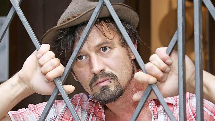 Auf dem Foto noch gestellt, aber bald vielleicht Realität: Straßenmusiker Moritz Rabe hinter Gittern. Fotos: Matthias Hoch