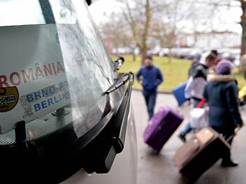 Fahrgäste eines aus Rumänien eingetroffenen Reisebuses gehen am 08.01.2014 in Berlin an einer Haltestelle des Zentralen Omnibusbahnhofes Berlin (ZOB) mit ihren Koffern zum Ausgang. Die Debatte über angebliche Armutszuwanderer aus Südosteuropa beschäftigt nun ein eigenes Gremium der Bundesregierung. Die Runde soll prüfen, ob und wie die Regierung gegen einen möglichen Missbrauch von Sozialleistungen durch Bürger anderer EU-Staaten vorgehen sollte. Foto: Marc Tirl/dpa