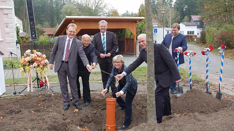 Die Dokumentenkapsel, die Zeitungsbeigaben von 1911 und 2014 enthält, wird versenkt (v l. ). CSU-Ortsverbandsvorsitzender Bernd Rebhan, Vorstand des Grieser Bundes Horst Piontek, Erster Bürgermeister Herbert Schneider, Frauen-Unionsvorsitzende Ursula Eberle-Berlips, Vorstandsmitglied der Garten- und Blumenfreunde Hans-Ludwig Solowan sowie aus dem Bauamt des Marktes Küps Christian Ebertsch. Foto: Andrea Hänel