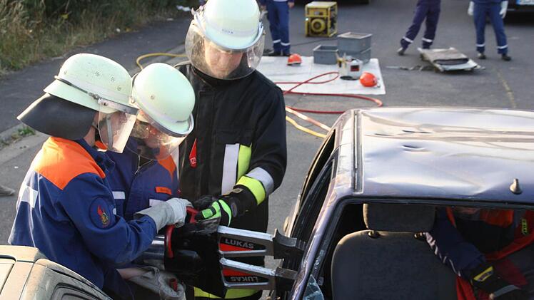 Ausbilder Michael Koch beobachtet die Marlene Gessner und Michael Müller bei ihrem Einsatz mit dem Spreizer. Foto: Daniel Wiener