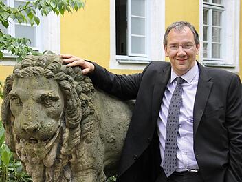 Thomas Nowak mit einem der Löwen vor seinem Amtssitz, dem Bürglaßschlösschen. Dass er berufsmäßiger Bürgermeister werden würde, sei so nicht geplant gewesen, sagt er. Nun leitet er das Sozialreferat der Stadt Coburg. Foto: Simone Bastian