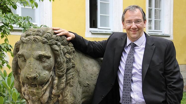 Thomas Nowak mit einem der Löwen vor seinem Amtssitz, dem Bürglaßschlösschen. Dass er berufsmäßiger Bürgermeister werden würde, sei so nicht geplant gewesen, sagt er. Nun leitet er das Sozialreferat der Stadt Coburg. Foto: Simone Bastian