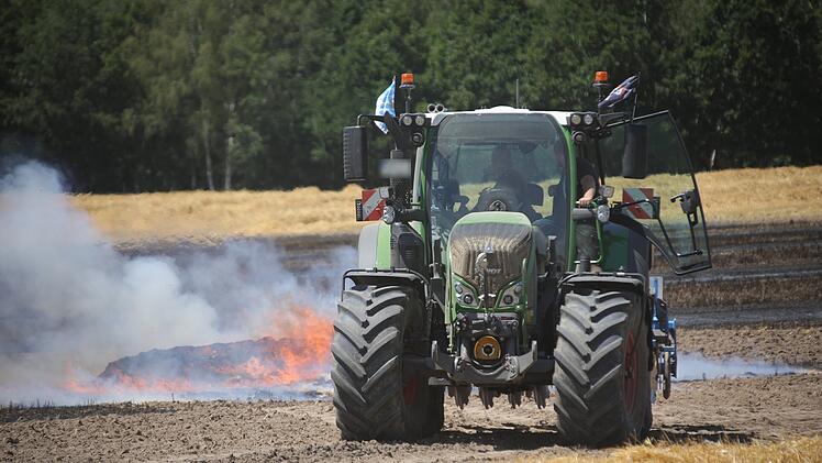 Entflammte Ballenpresse steckt Feld in Brand