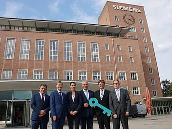 Der Schlüssel wurde schon mal übergeben, nutzen kann die FAU das Gebäude aber erst ab 2024. Im Bild: Zsolt Sluitner, CEO Siemens Real Estate, Klaus Helmrich, Mitglied des Vorstands der Siemens AG, Ministerin für Wissenschaft und Kunst, Marion Kiechle, Innenminister Joachim Herrmann, Joachim Hornegger, Präsident der FAU, Florian Janik (v. l.)      Foto: Pascale Ferry