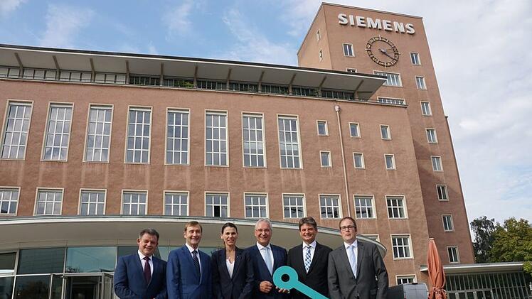 Der Schlüssel wurde schon mal übergeben, nutzen kann die FAU das Gebäude aber erst ab 2024. Im Bild: Zsolt Sluitner, CEO Siemens Real Estate, Klaus Helmrich, Mitglied des Vorstands der Siemens AG, Ministerin für Wissenschaft und Kunst, Marion Kiechle, Innenminister Joachim Herrmann, Joachim Hornegger, Präsident der FAU, Florian Janik (v. l.)      Foto: Pascale Ferry