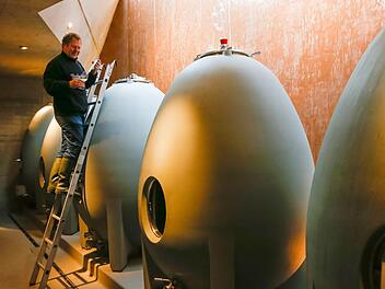 Ludwig Knoll zieht aus einem seiner Wein-Beton-Eier eine Probe.  Foto: Matthias Hoch