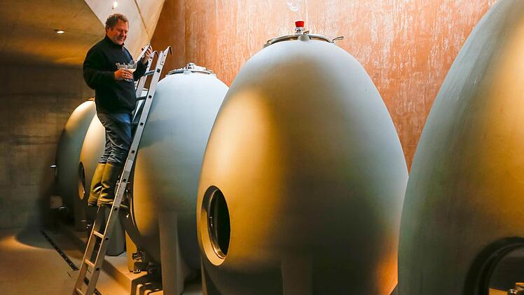 Ludwig Knoll zieht aus einem seiner Wein-Beton-Eier eine Probe.  Foto: Matthias Hoch