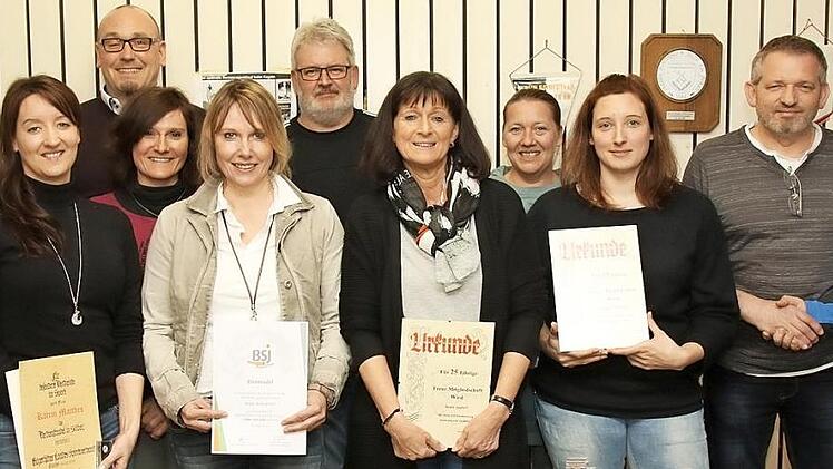 Die Geehrten des TSV Berterlsdorf (vorne) zusammen mit den neuen Vorstandsmitgliedern (hinten): Der scheidende Vorsitzende Michael Dietzel (rechts) übergibt symbolisch mit einem Handschlag den Verein an den neuen Vorsitzenden Uwe Schäftlein (Zweiter von rechts). Foto: Michael Stelzner
