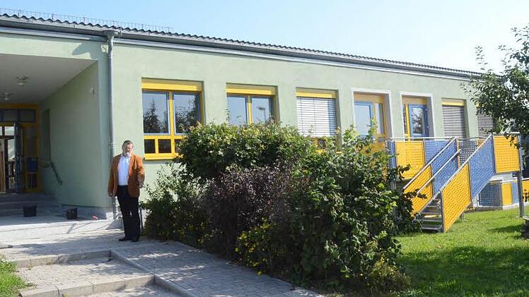 Zweiter Bürgermeister Arno Hoffmann weist auf die Rampe hin, die für einen barrierefreien Zugang zur Kindertagesstätte neu errichtet wurde. Rechts im Bild ist eine Fluchttreppe zu sehen die neu angebaut wurde. Foto: Karl-Heinz Hofmann