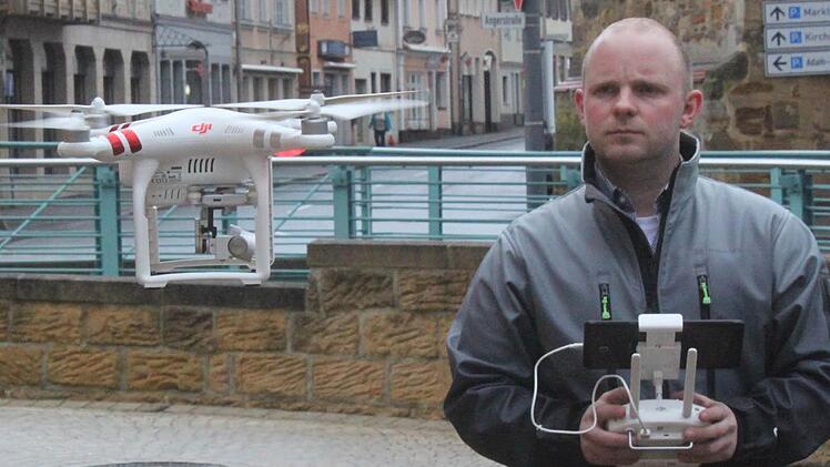 Marco Freitag mit einer seiner Drohnen. 2016 gründete der 28-jährige Landmaschinenmechaniker seine Firma "MF Drone Flight". Vom Boden aus sieht er auf dem Display in Echtzeit die Bilder, die seine Drohne gerade aufnimmt.  Foto: Matthias Einwag