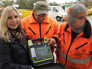 Andrea Singer (links) vom Zweckverband Abfallwirtschaft gab den Anstoß für die Anschaffung der Defibrillatoren. Auch der Wertstoffhof in Medbach - der übrigens auch nach der Abdeckung der Deponie weiter betrieben wird - wurde mit einem solchen Gerät ausgerüstet. Die Medbacher Mitarbeiter Carlo Sais (Mitte) und Volker Jörg (rechts) können damit umgehen, hoffen aber, es nie einsetzen zu müssen.  Foto: Andreas Dorsch