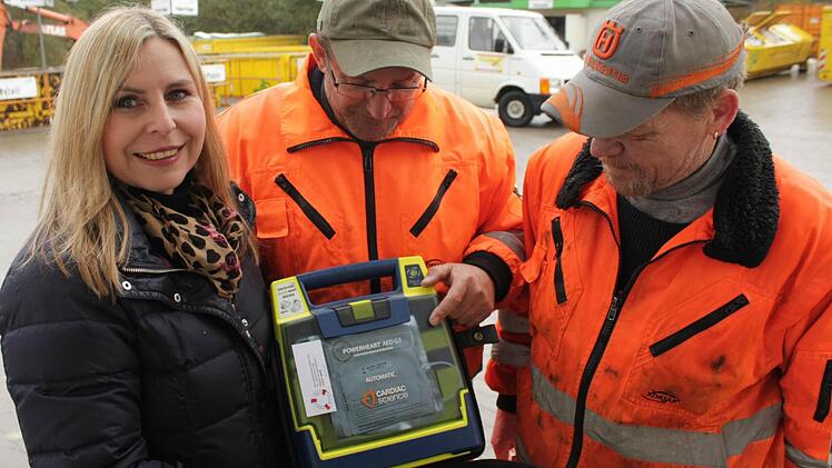 Andrea Singer (links) vom Zweckverband Abfallwirtschaft gab den Anstoß für die Anschaffung der Defibrillatoren. Auch der Wertstoffhof in Medbach - der übrigens auch nach der Abdeckung der Deponie weiter betrieben wird - wurde mit einem solchen Gerät ausgerüstet. Die Medbacher Mitarbeiter Carlo Sais (Mitte) und Volker Jörg (rechts) können damit umgehen, hoffen aber, es nie einsetzen zu müssen.  Foto: Andreas Dorsch