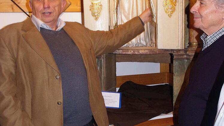 Pfarrarchivar Georg Schneider vor dem Altarthron des Hochaltars, der wahrscheinlich aus dem Vorgängeraltar stammt. Mit im Bild ist (rechts) Franz Geiger.
