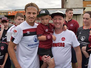 Als Profis zum Anfassen präsentierten sich die Club-Spieler am vergangenen Wochenende beim Testspiel gegen den Landesligisten FC Lichtenfels. Hier freuen sich der Burgkunstadter Heiko Baier (rechts), der ehemals für den ATS Kulmbach stürmte, und sein Sohn Tom über ein Erinnerungsbild mit FCN-Neuzugang Felix Lohkemper. Foto:  Gunther Czepera