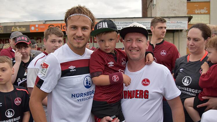 Als Profis zum Anfassen präsentierten sich die Club-Spieler am vergangenen Wochenende beim Testspiel gegen den Landesligisten FC Lichtenfels. Hier freuen sich der Burgkunstadter Heiko Baier (rechts), der ehemals für den ATS Kulmbach stürmte, und sein Sohn Tom über ein Erinnerungsbild mit FCN-Neuzugang Felix Lohkemper. Foto:  Gunther Czepera