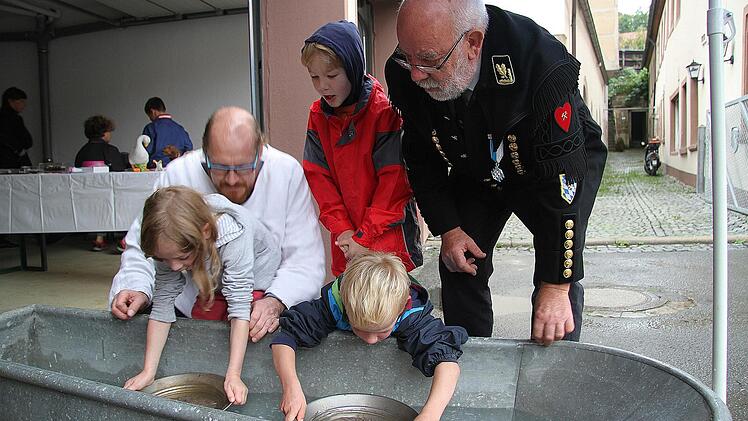 Auch bei Regen macht Edelstein waschen Spaß. Christian Kühl und Heinz Kliesch freuten sich über begeisterte Kinder. Foto: Sonja Adam