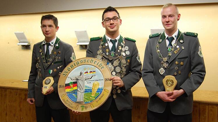 Schützenkönig 2014: 2. Ritter Matthias Happ, Schützenkönig Christopher Meindl und 1. Ritter Patrick Jopp. Die Königsscheibe mit Bezug auf das Jahr 2014 stiftete der alte Schützenkönig Michael Meindl. Foto: Straub