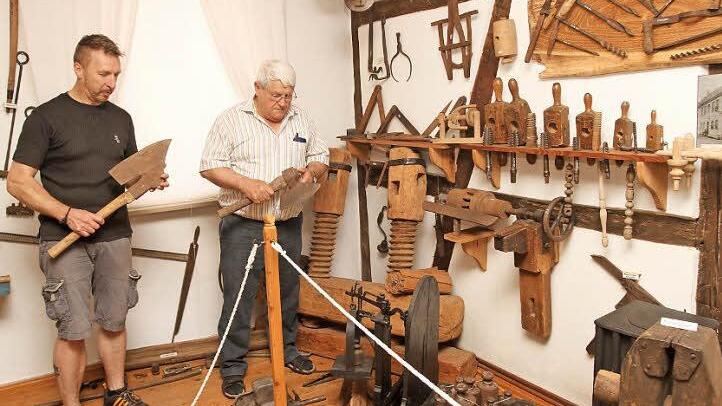 Im Eltmanner Heimatmuseum: Vorsitzender Rainer Reitz und Museumsleiter Willi Lediger (von links) inmitten der Werkzeuge für die Holzbearbeitung und mit besonderen Beilen in der Hand Fotos: Günther Geiling