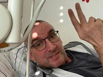 Ein Foto, das kaum ein Arzt für möglich gehalten hätte: Bad Bocklets Bürgermeister Andreas Sandwall liegt im Krankenhaus nach fünf Wochen Koma - und hält die Hand siegessicher mit dem Victory-Zeichen in die Luft. Er sollte Recht behalten: Er ist nach einer schweren Hirnblutung vollkommen gesund ins Leben zurückgekommen. Foto: Andreas Sandwall, Selbstauslöser