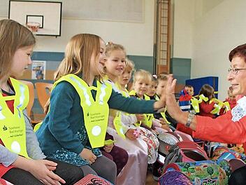 Roswitha Kaufmann von der Saale-Zeitung verteilte die Sicherheitsdreiecke an die Schulanfänger. Mit Handschlag versprachen ihr Mädchen, die Dreiecke auch zuverlässig zu tragen. Foto: Heike Beudert