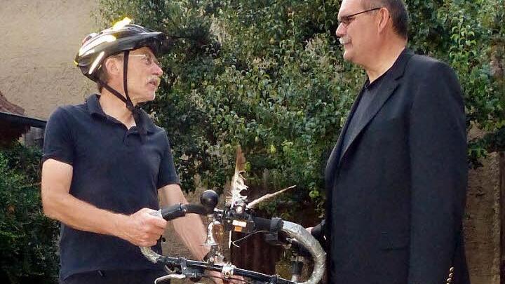 Welttouren-Radler Manfred Wagner (links) im Gespräch mit unserem Redakteur Klaus Schmitt: Das Fahrrad zwischen beiden ist sein Heimat-Fahrrad, das Weltenbummler-Fahrrad wird derzeit für die nächste Tour überholt. Übrigens: Manfred Wagner benutzt ein weitgehend normales Rad; es hat nur einen besonderen Rahmen (aus Stahl) und eine besonders hochwertige Schaltung. Um solche Touren, wie er sie fährt, zu bewältigen, kommt es nach seiner Ansicht mehr auf den Fahrer als auf das Zweirad an.  Foto: In...