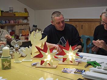 Im Haus Fischbachtal wird fleißig für den Adventsbasar gewerkelt. Von links: Udo filzt eine Maus. Torsten hilft Michael bei der Montage eines "Lichterwaldes" Foto: K.- H. Hofmann
