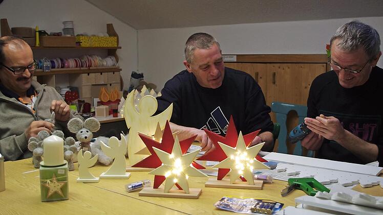Im Haus Fischbachtal wird fleißig für den Adventsbasar gewerkelt. Von links: Udo filzt eine Maus. Torsten hilft Michael bei der Montage eines "Lichterwaldes" Foto: K.- H. Hofmann