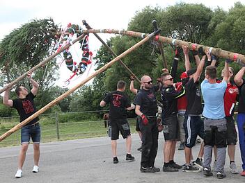 Nur mit vereinten Kräften kann der buntgeschmückte Baum stehen.
