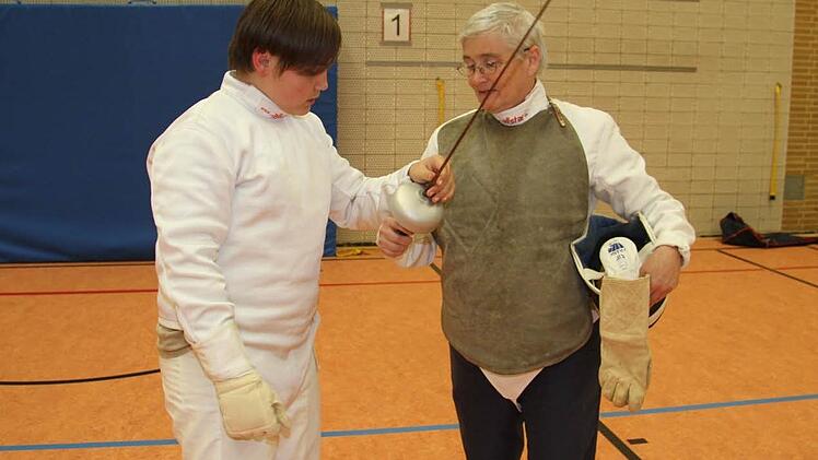Heike Rahn zeigt David Weber die richtige Griffhaltung.