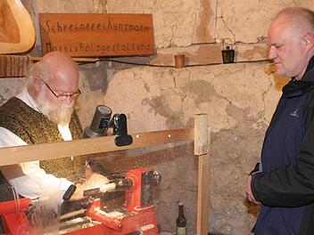 Unter den Augen  eines Besuchers        fräst  Ernst Kunzmmann eine Weihnachtsfigur zurecht. Foto: fra-press