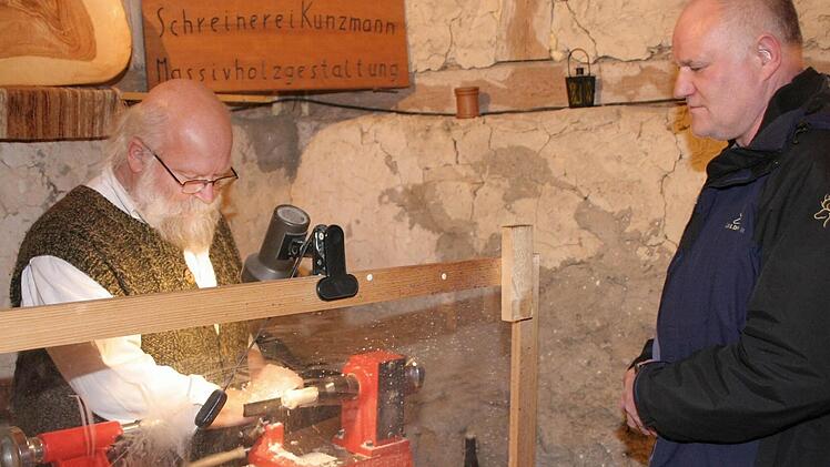 Unter den Augen  eines Besuchers        fräst  Ernst Kunzmmann eine Weihnachtsfigur zurecht. Foto: fra-press