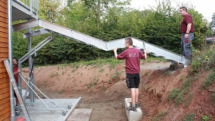 Hier justieren die Arbeiter eine neue Metalltreppe.