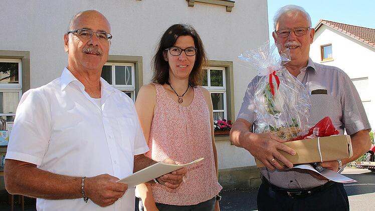 Die Ehrennadel für besondere Verdienste übergab Peter Saal (rechts) im Auftrag von Bischof Franz Jung an Fridolin Weigand (links). In der Mitte Alexandra Kehl, die Vorsitzende des Gemeindeteams. Foto: Dieter Britz