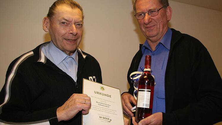 Freudig nimmt Karl Fischer (links) von Hermann Lochner die Urkunde für 40 Jahre Treue zum Imkerverein entgegen