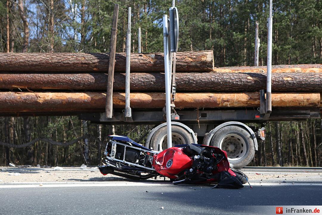 Motorradfahrer rutscht unter Lastwagen