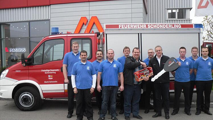 Stolz auf ihr neues Fahrzeug ist die Schönderlinger Feuerwehr, in der Mitte Bürgermeister Bernold Martin, mit einem kleinen Modell, und Kommandant Marko Knüttel, mit dem großen Schlüssel. Foto: Oswald Türbl