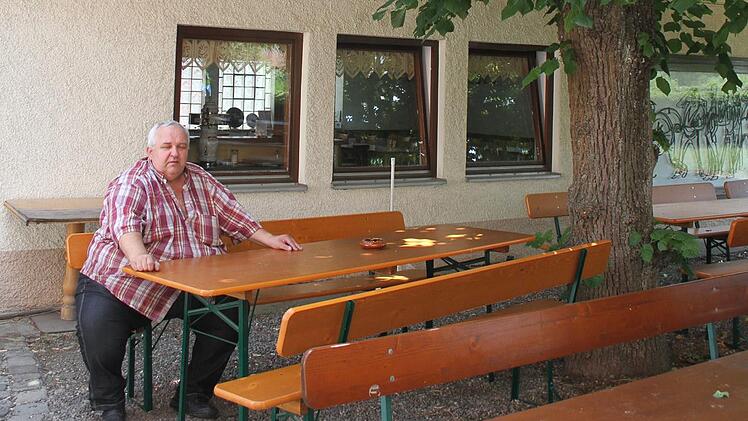 Karl-Heinz Schröder sitzt resigniert und traurig in seinem Biergarten. Foto: Sonny Adam