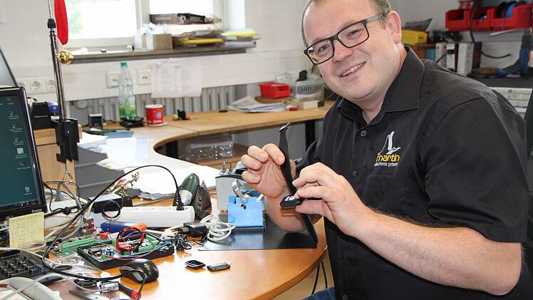 Marco Zinkand, Abteilungsleiter Produktion, setzt die Notfalluhren in der Werkstatt der Firma Martin Elektrotechnik zusammen. Foto: Ulrike Müller