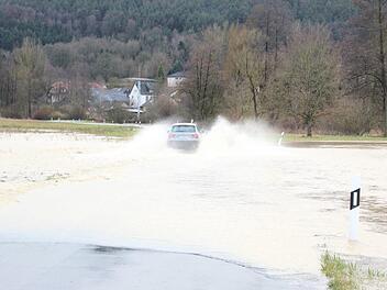 Trotz der Sperre der Straße zwischen Mitwitz und Steinach fuhren am Nachmittag einige Fahrzeuge durch die Wassermassen. Foto: Anna-Lena Deuerling