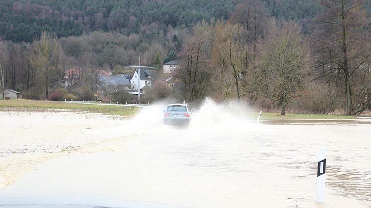 Trotz der Sperre der Straße zwischen Mitwitz und Steinach fuhren am Nachmittag einige Fahrzeuge durch die Wassermassen. Foto: Anna-Lena Deuerling