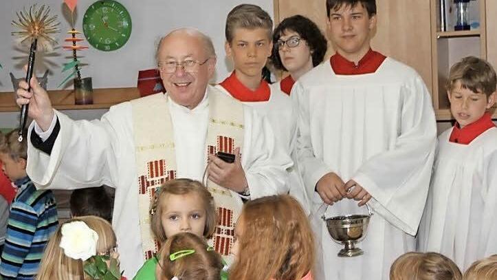Pfarrer Franz Noppenberger weiht sie sanierten Räume im Kindergarten ein. Foto: Erlwein