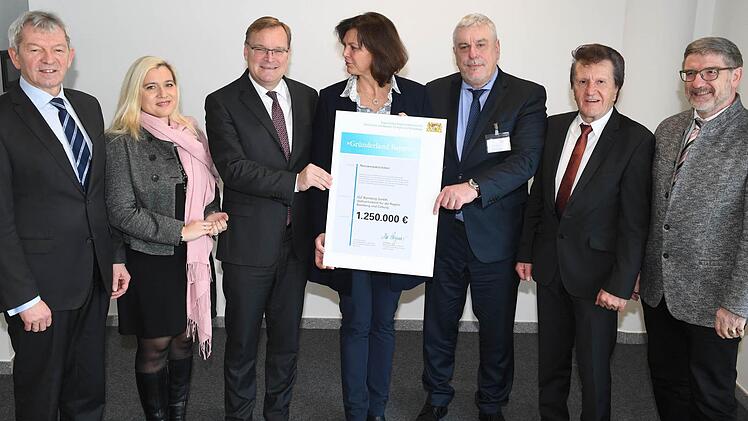 Übergabe des Förderbescheids (v.l.): Bambergs Landrat Johann Kalb, Ministerin Melanie Huml, Bambergs OB Andreas Starke, Wirtschaftsministerin Ilse Aigner, Coburgs OB Norbert Tessmer, Coburgs IHK-Präsident Friedrich Herdan sowie Coburgs Landrat Michael Busch. Foto: Ronald Rinklef