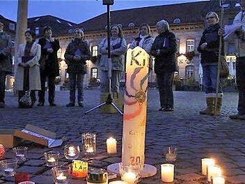 Teilnehmer des Donnerstagsgebets bilden  auf dem Marktplatz einen Kreis um brennende Kerzen.  Foto: Gerd Schaar