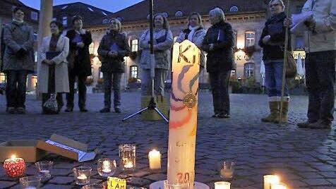 Teilnehmer des Donnerstagsgebets bilden  auf dem Marktplatz einen Kreis um brennende Kerzen.  Foto: Gerd Schaar