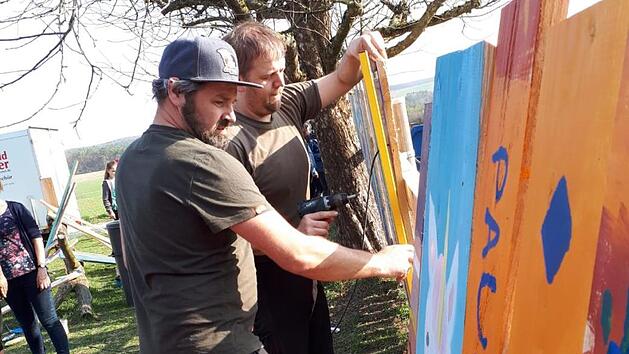 Einige Helfer aus Rannungen haben den Zaun am Spielplatz bunt angemalt. Foto: Nathalie Langer
