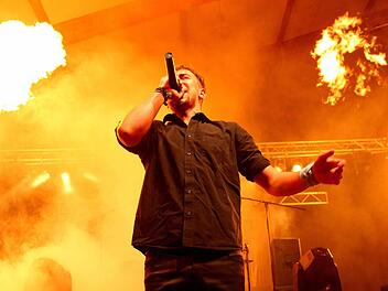 Christopher Zillig schmetterte die Songs auch inmitten der lodernden Flammen. Seine Band "Infected Authoritah" lockte am Samstagabend mehr als 500 Besucher zu ihrem Auftritt in die Stadthalle. Die Stimmung war am Toben. Foto: Manuel Stark