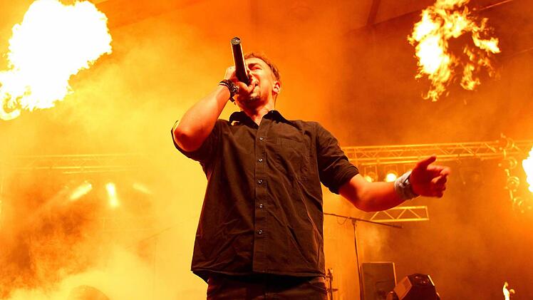 Christopher Zillig schmetterte die Songs auch inmitten der lodernden Flammen. Seine Band "Infected Authoritah" lockte am Samstagabend mehr als 500 Besucher zu ihrem Auftritt in die Stadthalle. Die Stimmung war am Toben. Foto: Manuel Stark